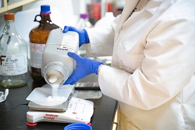 scientist pouring out powder